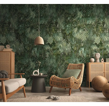 Vliesbehang met junglepatroon en palmbladeren in een moderne woonkamer met rotan meubels en een houten dressoir.