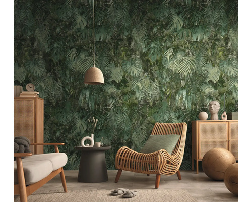 Vliesbehang met junglepatroon en palmbladeren in een moderne woonkamer met rotan meubels en een houten dressoir.