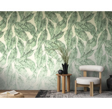 Lichte woonkamer met botanisch fotobehang met groot bladpatroon, moderne fauteuil, houten bijzettafel en decoratieve elementen.