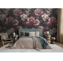 Vliesbehang met een groot bloemenpatroon in een slaapkamer met een groen hoofdbord en houten stoel.