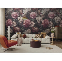 Woonkamer met donker bloemenbehang, witte bank, oranje fauteuil, ronde salontafel en licht tapijt in een modern ontwerp.