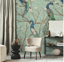 Moderne woonkamer met fotobehang van pauwen op bloeiende takken, gecombineerd met een lichte fauteuil en zwarte meubels.