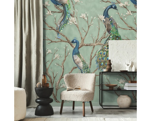 Moderne woonkamer met fotobehang van pauwen op bloeiende takken, gecombineerd met een lichte fauteuil en zwarte meubels.