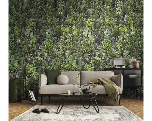 Moderne woonkamer met groen kruidenbehang, grijze bank, zwarte metalen salontafel en visgraatparket.