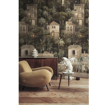 Woonkamer met donker fotobehang met huis- en palmboommotief, beige fauteuil, houten meubels en parketvloer.