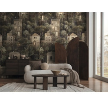 Woonkamer met donker fotobehang met een patroon van mediterrane gebouwen en palmbomen. Inclusief witte bank en houten tafel.