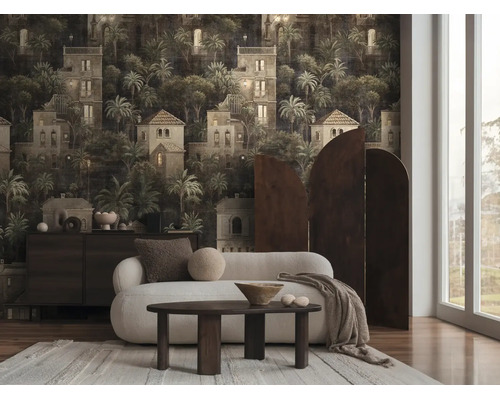 Woonkamer met donker fotobehang met een patroon van mediterrane gebouwen en palmbomen. Inclusief witte bank en houten tafel.