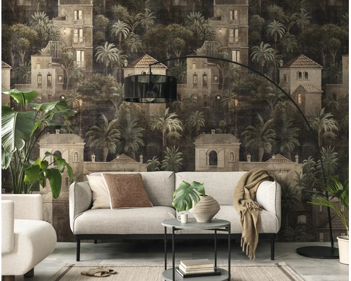 Moderne woonkamer met fotobehang van een mediterraan landschap met villa's en palmbomen achter een lichte bank.