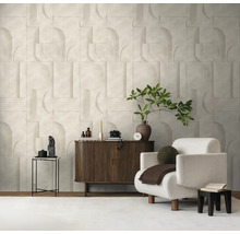 Helder ingerichte woonkamer met een gestructureerde wand in geometrische optiek, een donkerhouten dressoir en een witte fauteuil.