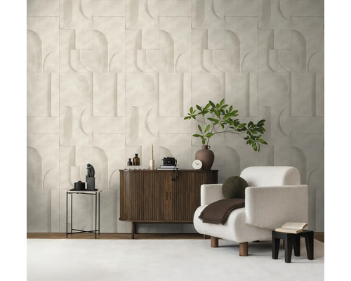 Helder ingerichte woonkamer met een gestructureerde wand in geometrische optiek, een donkerhouten dressoir en een witte fauteuil.
