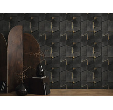 Vliesbehang met geometrisch 3D-steenpatroon in antraciet en goud in een moderne woonkamer met kamerscherm en donkere decoratie.