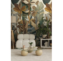 Vliesbehang met botanisch patroon van gestileerde bladeren in een moderne woonkamer met fauteuil en glazen salontafel.