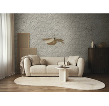 Modern ingerichte woonkamer met grafisch vliesbehang op de muur, een lichte stoffen bank en een vloerkleed met organische vormen.