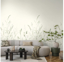 Moderne woonkamer met fotobehang met grasprint, een lichtgrijze bank, donkere salontafel en parketvloer.
