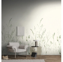 Wandvullend behang met grasmotief in een lichte woonkamer met een moderne fauteuil en houten vloer.