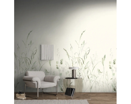 Wandvullend behang met grasmotief in een lichte woonkamer met een moderne fauteuil en houten vloer.