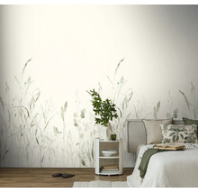 Fotobehang met natuurmotief, delicate grassen en planten in zachte groentinten, slaapkamer met licht bed, rustig en luchtig design.