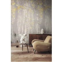 Fotobehang met bosmotief en gele bladeren in een moderne woonkamer met houten tafel, dressoir en fauteuil.