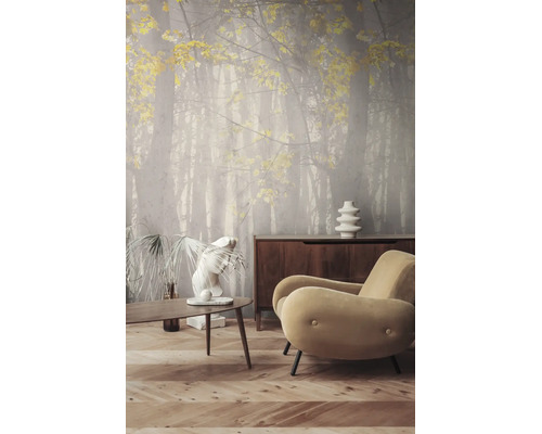 Fotobehang met bosmotief en gele bladeren in een moderne woonkamer met houten tafel, dressoir en fauteuil.