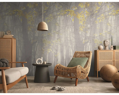 Woonkamer met fotobehang van een mistig bos, rotan fauteuil, houten dressoirs en een hanglamp met geweven kap.