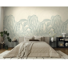 Licht ingerichte slaapkamer met groot fotobehang met palmbladeren, beige tweepersoonsbed, bijzettafels en moderne decoratie.