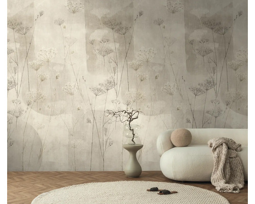 Vliesbehang met bloemenmotief in een lichte woonkamer met ronde bank, vloerkleed en visgraatparket.