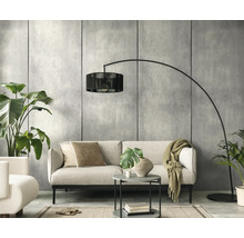 Moderne woonkamer met lichte bank, zwarte booglamp, ronde bijzettafel en kamerplanten voor een muur in betonlook.
