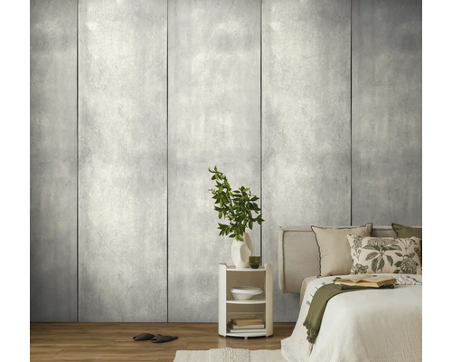 Modern slaapkamerinterieur met grootformaat wandpanelen in grijze betonlook, lichte houten vloer en een wit nachtkastje.