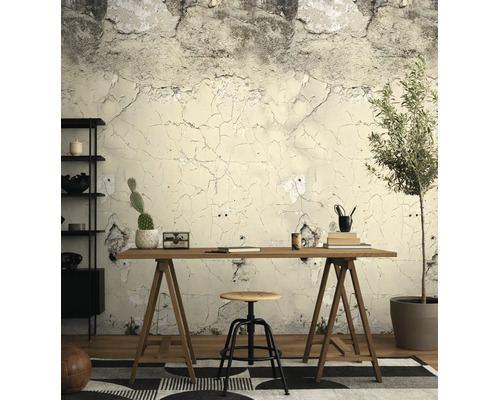 Vliesbehang met betonlook en barstjes in een werkkamer met een houten bureau, een kruk en een kamerplant.