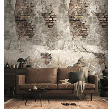 Woonkamer met fotobehang in baksteen- en stucwerklook, bruine bank, zwarte salontafel en vloerkleed met patroon in industriële stijl.