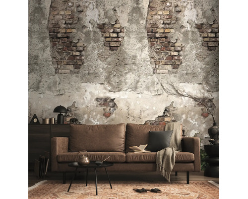 Woonkamer met fotobehang in baksteen- en stucwerklook, bruine bank, zwarte salontafel en vloerkleed met patroon in industriële stijl.