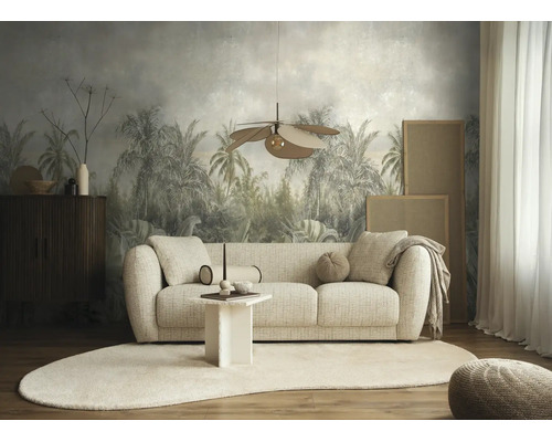 Moderne, lichte woonkamer met een bank van structuurstof, ovaal tapijt en fotobehang met een tropisch palmmotief op de achtergrond.