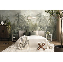 Fotobehang met jungle-motief en palmbomen in een licht ingerichte slaapkamer met tweepersoonsbed, houten meubels en planten.