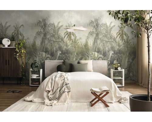 Fotobehang met jungle-motief en palmbomen in een licht ingerichte slaapkamer met tweepersoonsbed, houten meubels en planten.