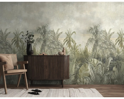 Fotobehang met tropisch jungle-motief in gedempte kleuren, palmbomen en grote bladeren in vintage stijl achter een houten dressoir.