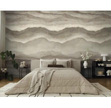 Moderne slaapkamer met abstract fotobehang in zandduin-look, beige bed en minimalistische meubels.