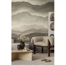 Fotobehang met abstract berglandschap in natuurtinten in een modern ingerichte woonkamer met fauteuil en salontafel.
