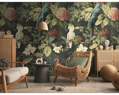 Fotobehang met botanisch jungle-motief, vogels en bloemen in een woonkamer met rotan meubels en een donkere achtergrond.