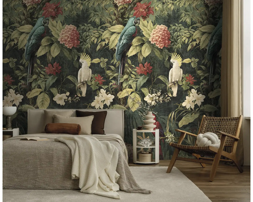 Slaapkamer met fotobehang in jungle-ontwerp met papegaaien en bloemen, een bed met licht textiel en een houten stoel.