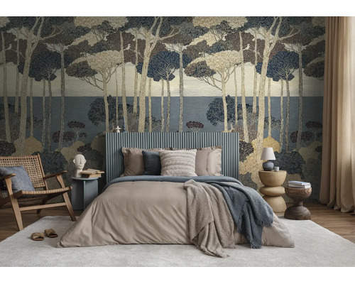 Slaapkamer met vliesbehang met bosmotief, een bed met grijs hoofdbord en een houten fauteuil op een tapijt.