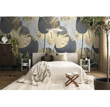 Moderne, lichte slaapkamer met behang met groot bladpatroon, gestoffeerd bed, houten meubels en kamerplanten.