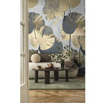 Moderne woonkamer met botanisch behang met grote bladeren, witte bank, donkerhouten salontafel en vloerlamp.