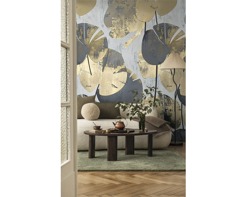 Moderne woonkamer met botanisch behang met grote bladeren, witte bank, donkerhouten salontafel en vloerlamp.