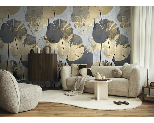 Moderne woonkamer met groot botanisch behang met grijze en gouden bladpatronen, bank, fauteuil en dressoir van donker hout.