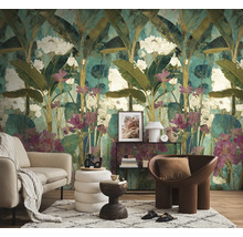 Woonkamer met een fotobehang in jungle-stijl met grote bladeren en bloemen, een bank, een fauteuil en een vloerkleed.