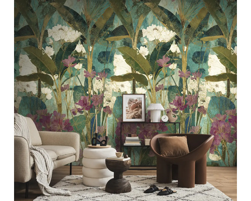 Woonkamer met een fotobehang in jungle-stijl met grote bladeren en bloemen, een bank, een fauteuil en een vloerkleed.