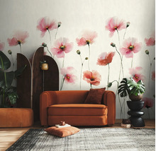 Fotobehang met roze aquarel klaprozen in een modern ingerichte woonkamer met oranje fauteuil, kamerscherm en kamerplanten.
