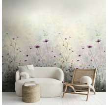 Vliesfotobehang met aquarel wildbloemenpatroon in lichte woonkamer met witte bank, rotan stoel en jute hocker.