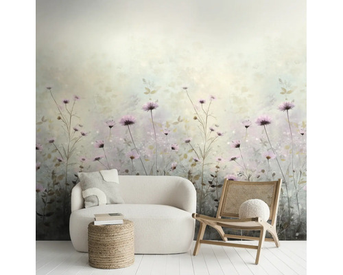 Vliesfotobehang met aquarel wildbloemenpatroon in lichte woonkamer met witte bank, rotan stoel en jute hocker.