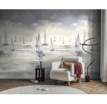 Fotobehang met zeilboten op zee in een modern ingerichte woonkamer met fauteuil, vloerlamp en vloerkleed op een parketvloer.